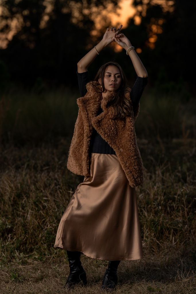 Elegant fall evening outfit with a satin skirt, fitted knit and heeled boots