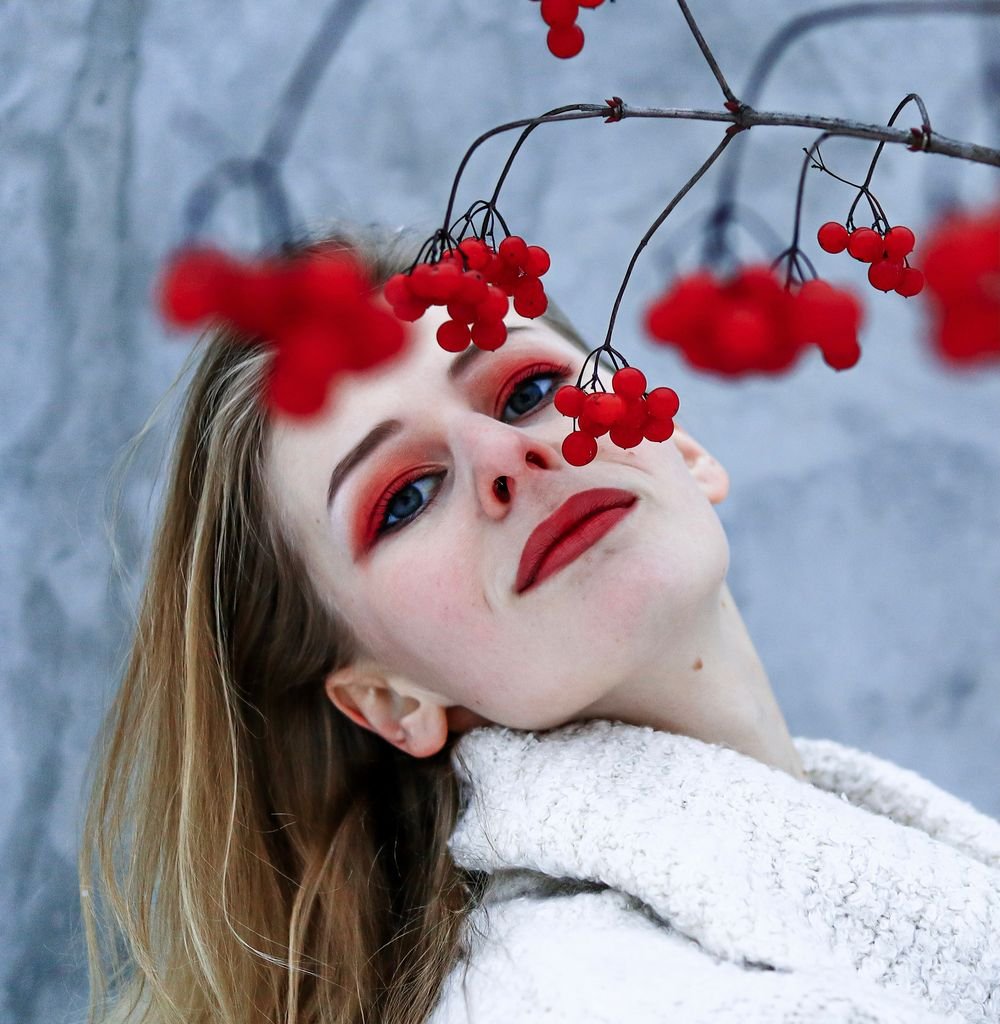 Woman with dewy winter makeup and berry lips in soft daylight