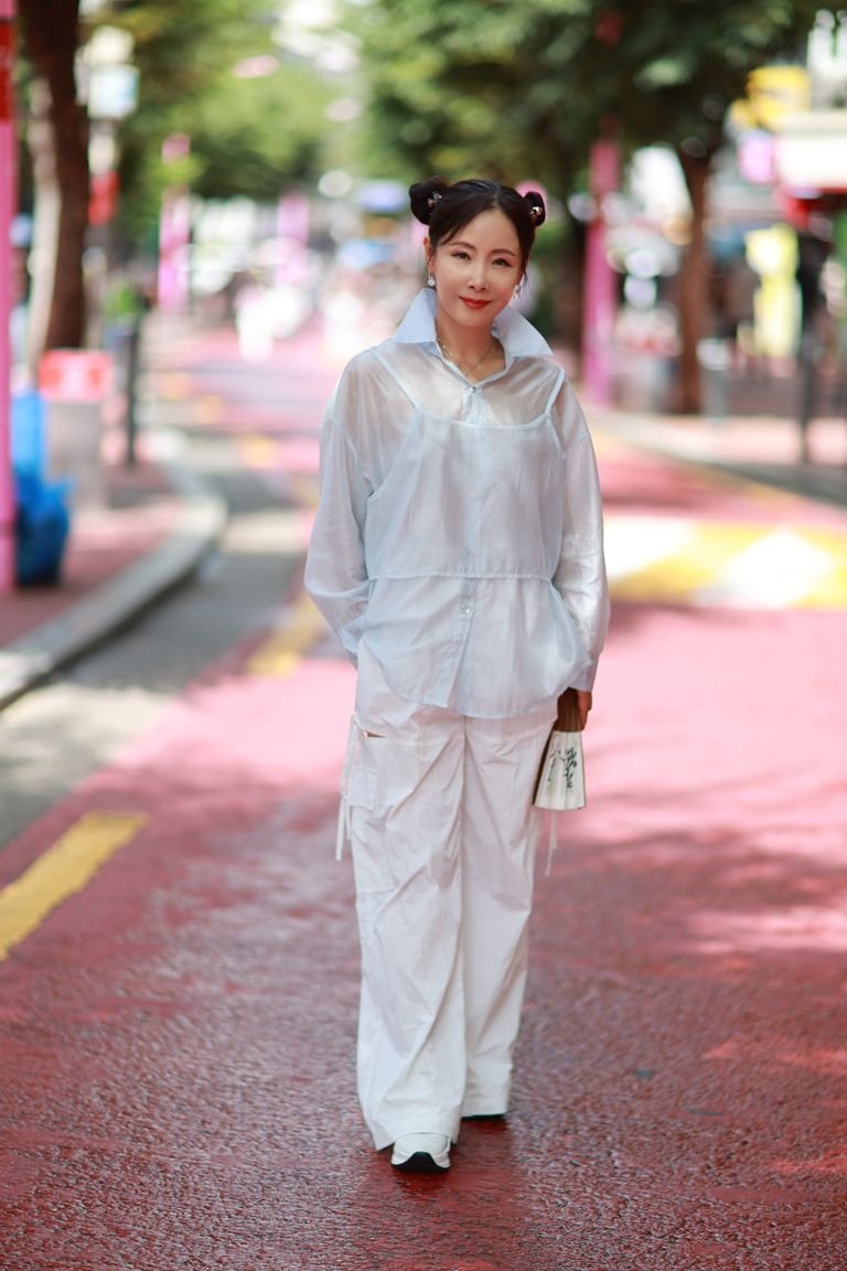 Korean woman in a white casual outfit on a colorful Seoul street — Korean casual outfit ideas