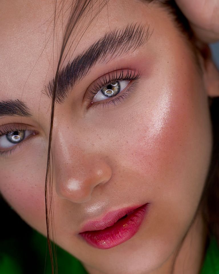 Woman with a winter makeup look featuring glowing skin and a berry lip.