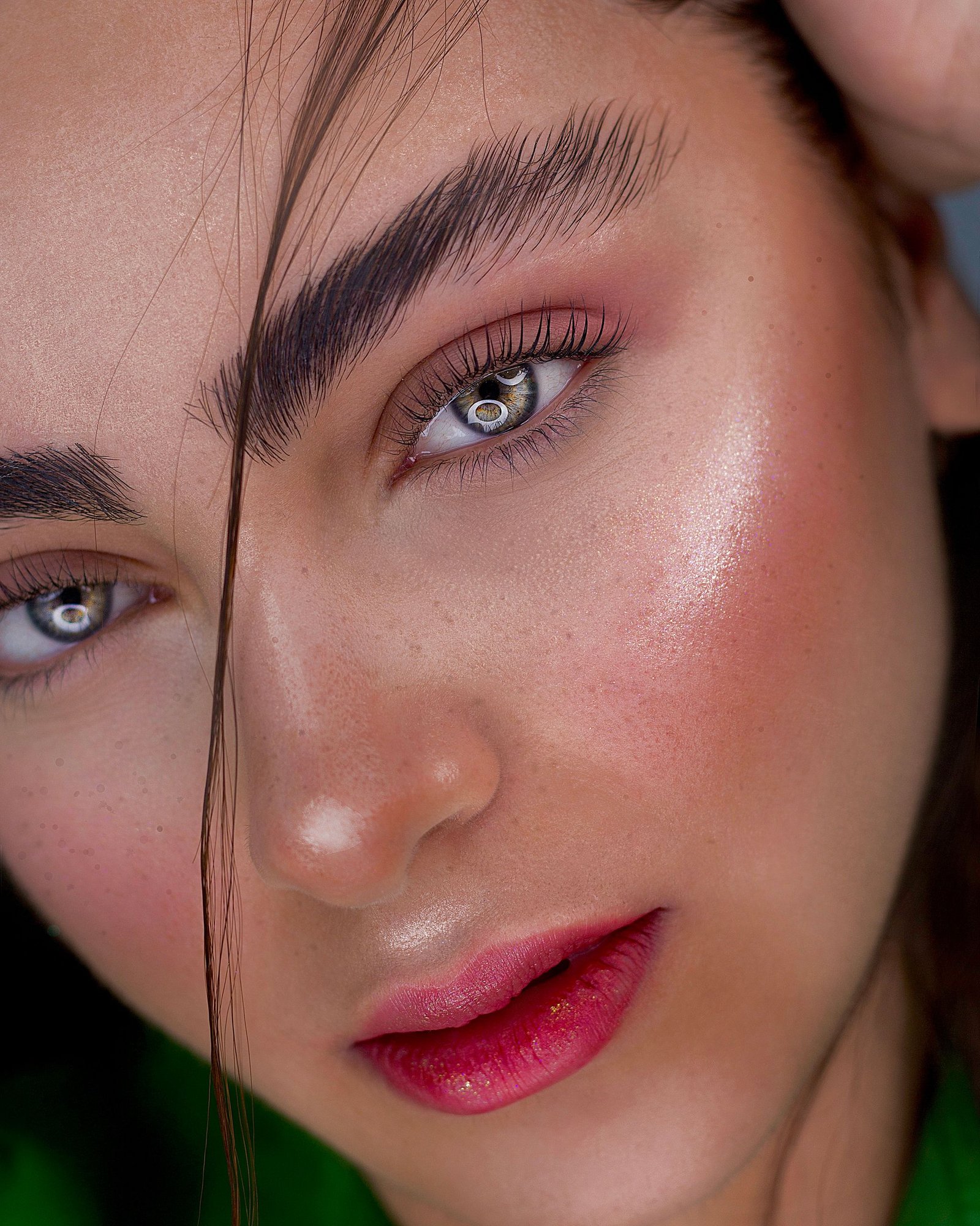 Woman with a winter makeup look featuring glowing skin and a berry lip.