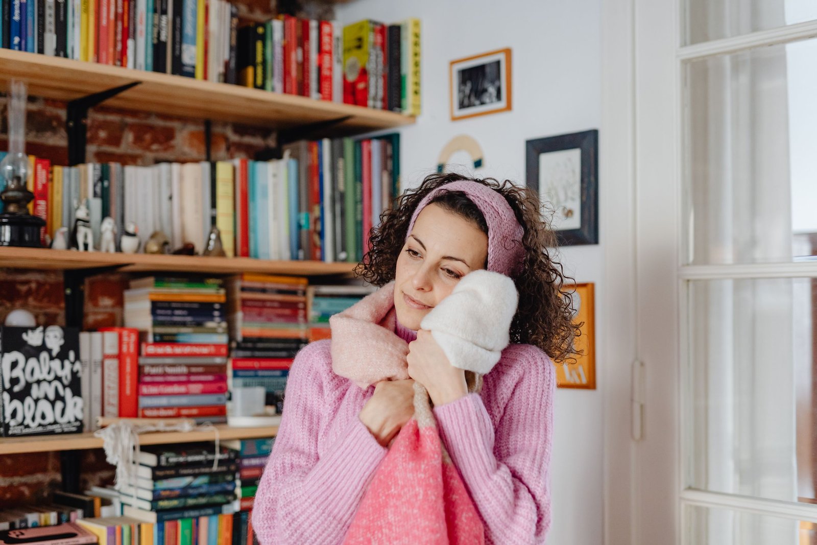 Woman enjoying a cozy winter self-care routine with a warm drink and soft blanket